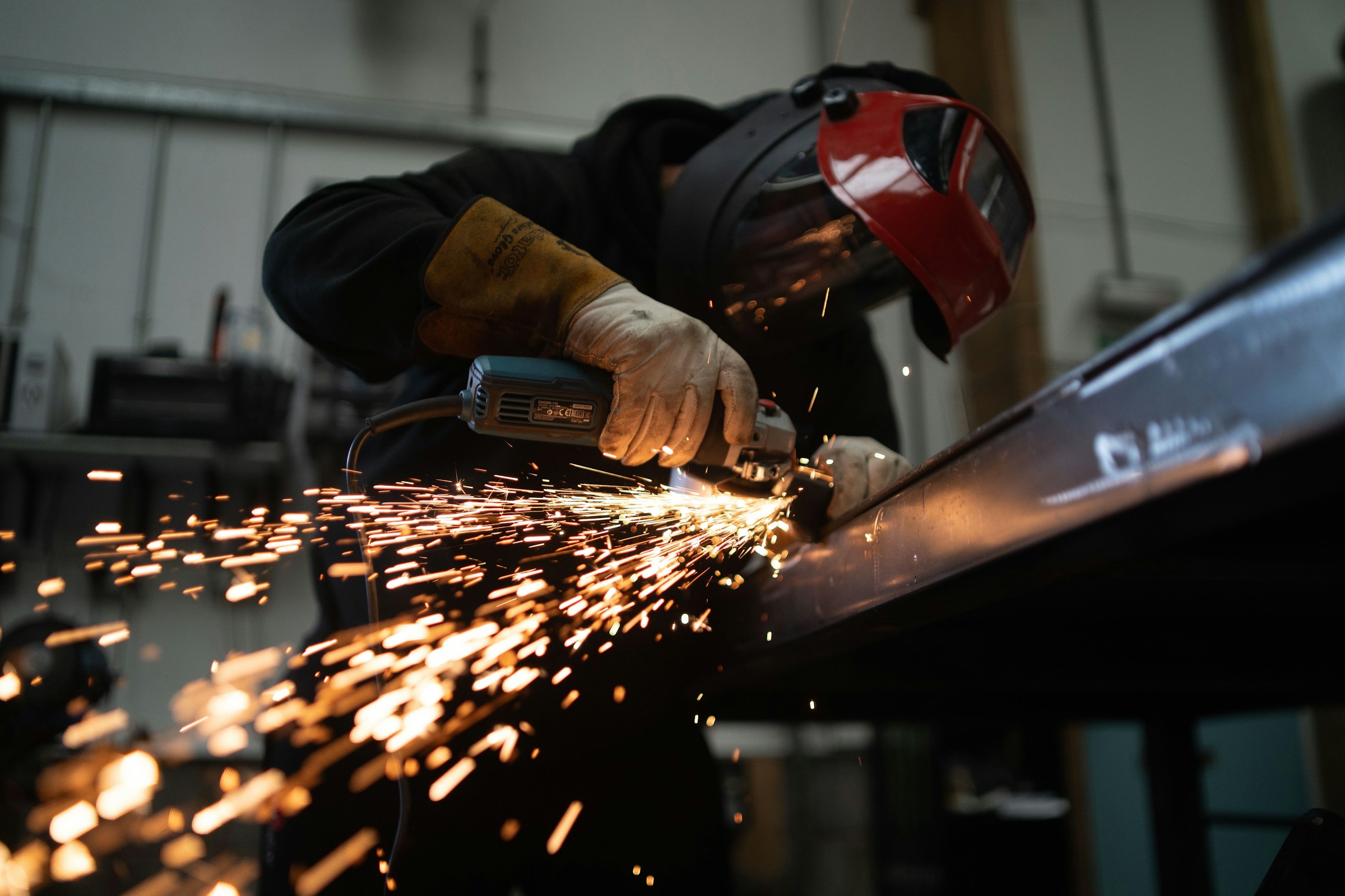 Worker holding a wooden rolling pin in an industrial setting